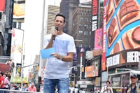 a man is holding a microphone in times square