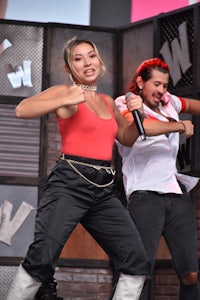 a woman wearing a red top and black pants