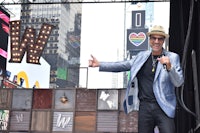 a man in a hat is standing on a stage