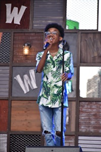 a young boy singing into a microphone