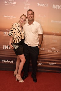 a man and woman posing on a red carpet
