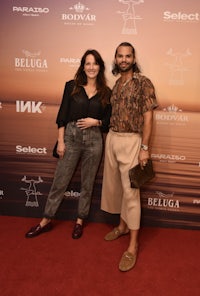 a man and woman standing on a red carpet at an event