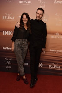 a man and woman standing on a red carpet