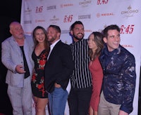 a group of people posing for a picture on a red carpet