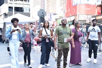 a group of people standing on a street in times square
