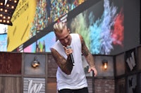 a man with tattoos singing into a microphone