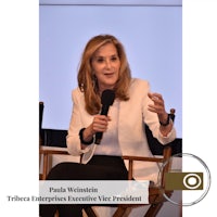 a woman is sitting in a chair and speaking into a microphone