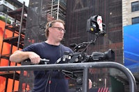 a man holding a camera in front of a building