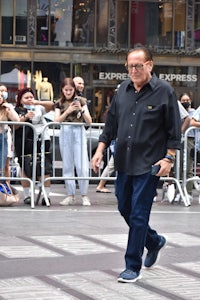a man crossing the street in front of a crowd of people