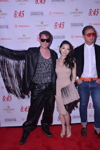 three people posing for a picture on a red carpet